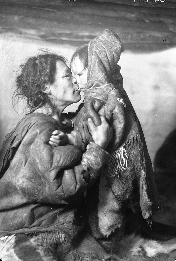 An Inuk mother with her child in the community of Padlei (in modern Nunavut), circa 1950. The remote Inuit community was heavily affected by the 1950 Caribou Inuit famine, which was caused by a change in the migratory behavior of their primary food source. Approx. 60 people died. [600 x 889]