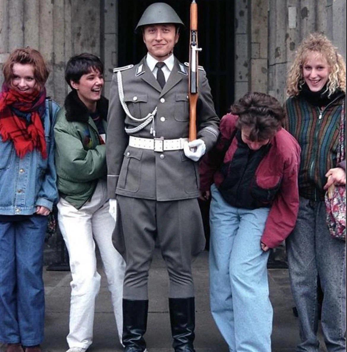 Tourists from the West, checking out an East German body guard, 1980s, East Germany [1170 x 1187]