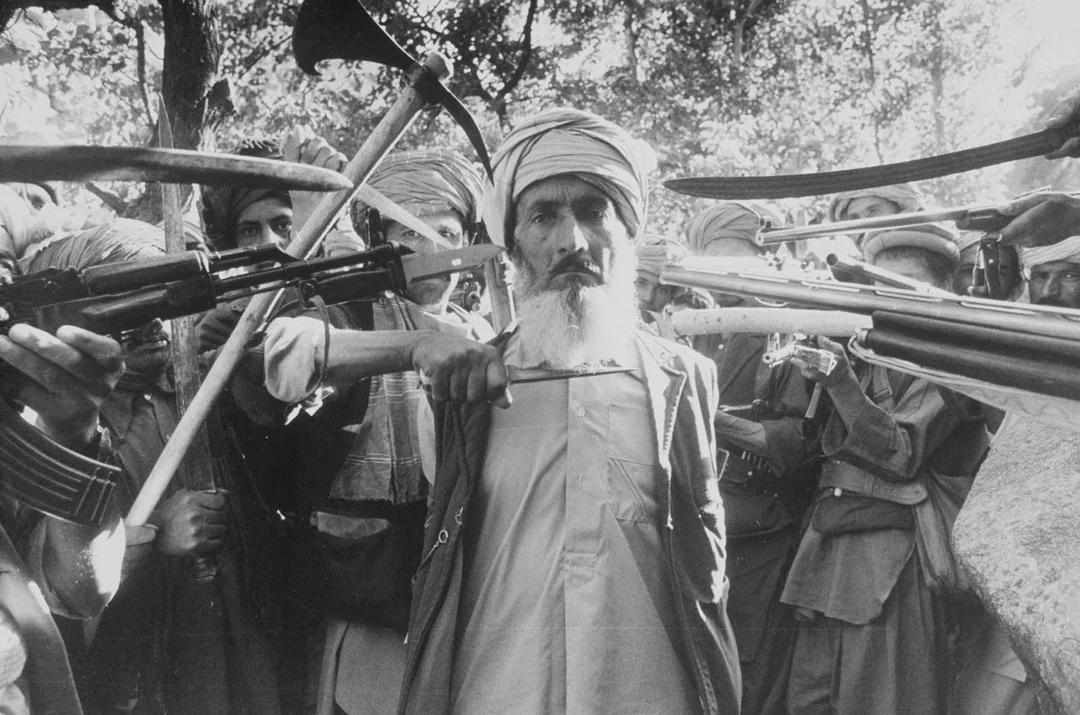 Afghan mujahideen fighters preparing to execute a man who was discovered working with Soviet forces, 1980. [1080×715]