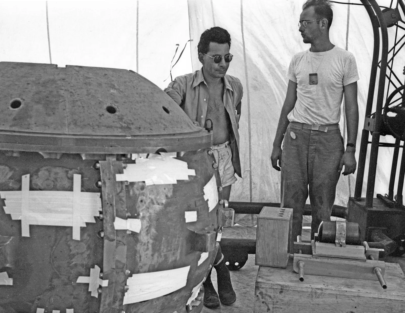 Manhattan Project physicist Louis Slotin posing with Herb Lehr besides the first nuclear bomb: The Trinity “Gadget” partially assembled, 1945 [1600×1238]