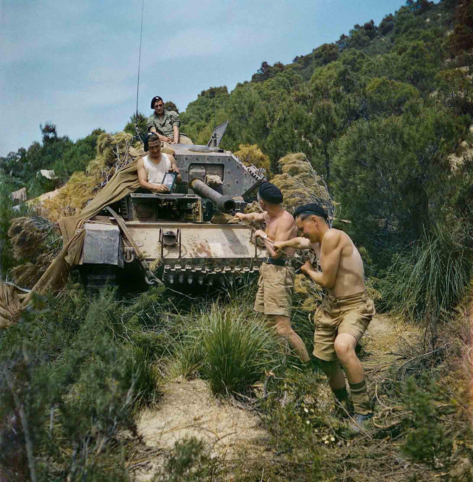 A crew from the 16th/5th Lancers, 6th Armoured Division, clean the gun barrel of their Crusader tank at El Aroussa in Tunisia, 1943.[1600×1632]