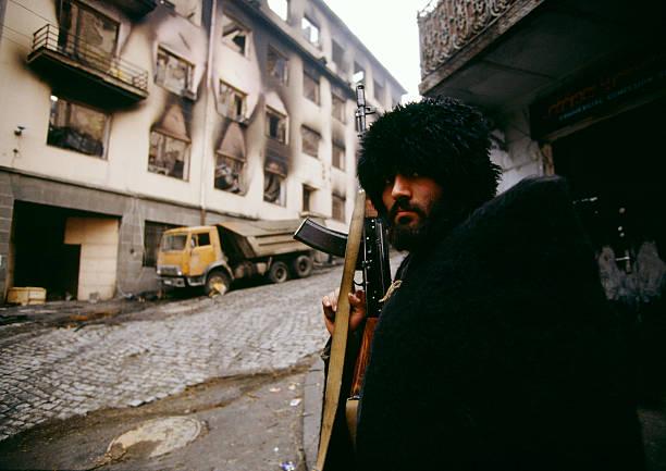 December 30th, 1991: A Georgian fighter with an AK-47 rifle waits behind a corner in Tbilisi during confrontations between partisans and anti-Gamsakhurdia groups during the Georgian civil war (612×433)