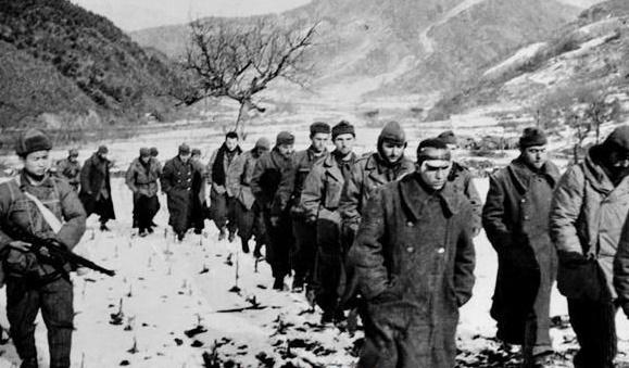 Chinese soldier of the “People’s Volunteer Army” escorting American prisoners of war after the campaign of the Yalu River, Korea, December 1950. [579×339]
