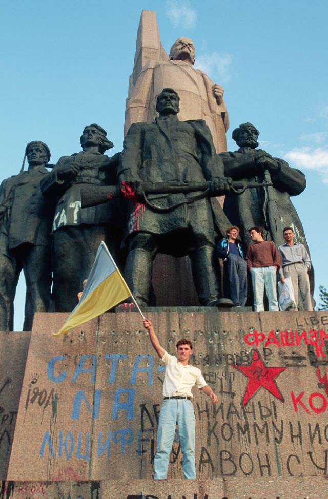 Young man waving the Ukrainian flag on the graffitied base of the Monument of the Great October Revolution in Kyiv – directly following Ukraine’s declaration of independence from the Soviet Union on August 24th, 1991. Photo was taken by American photojournalist Peter Turnley. [640 x 974]