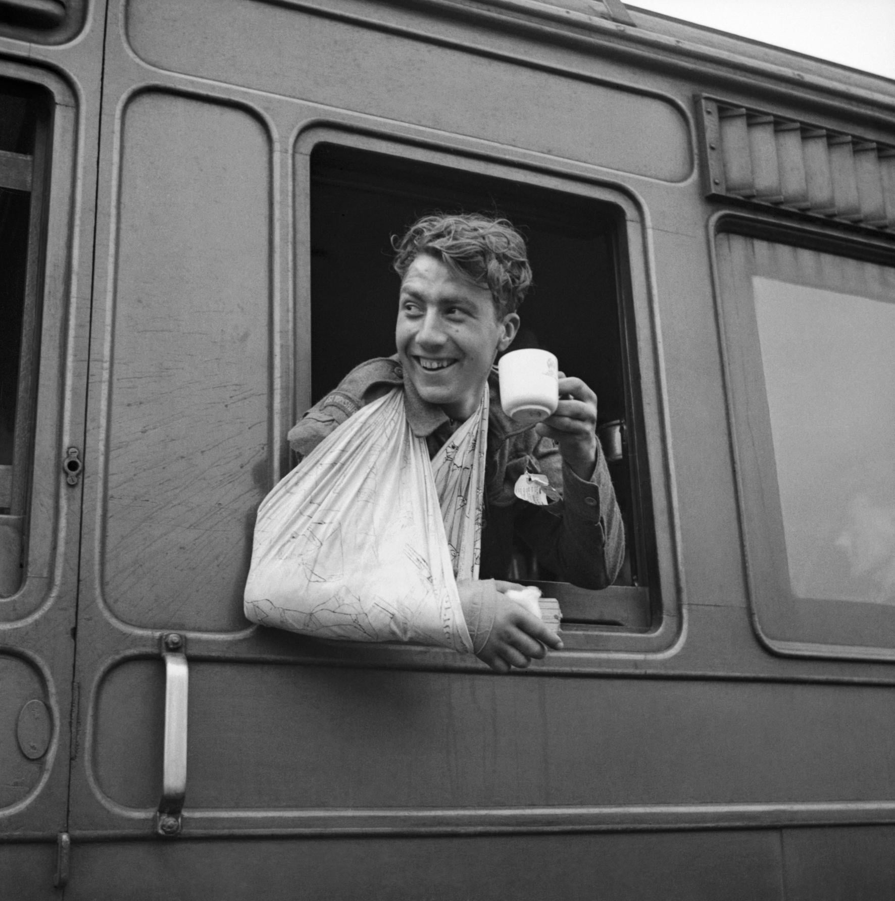 A wounded soldier, evacuated from Normandy, enjoys a cup of tea on a hospital train. 7 June 1944 [1772 × 1785]