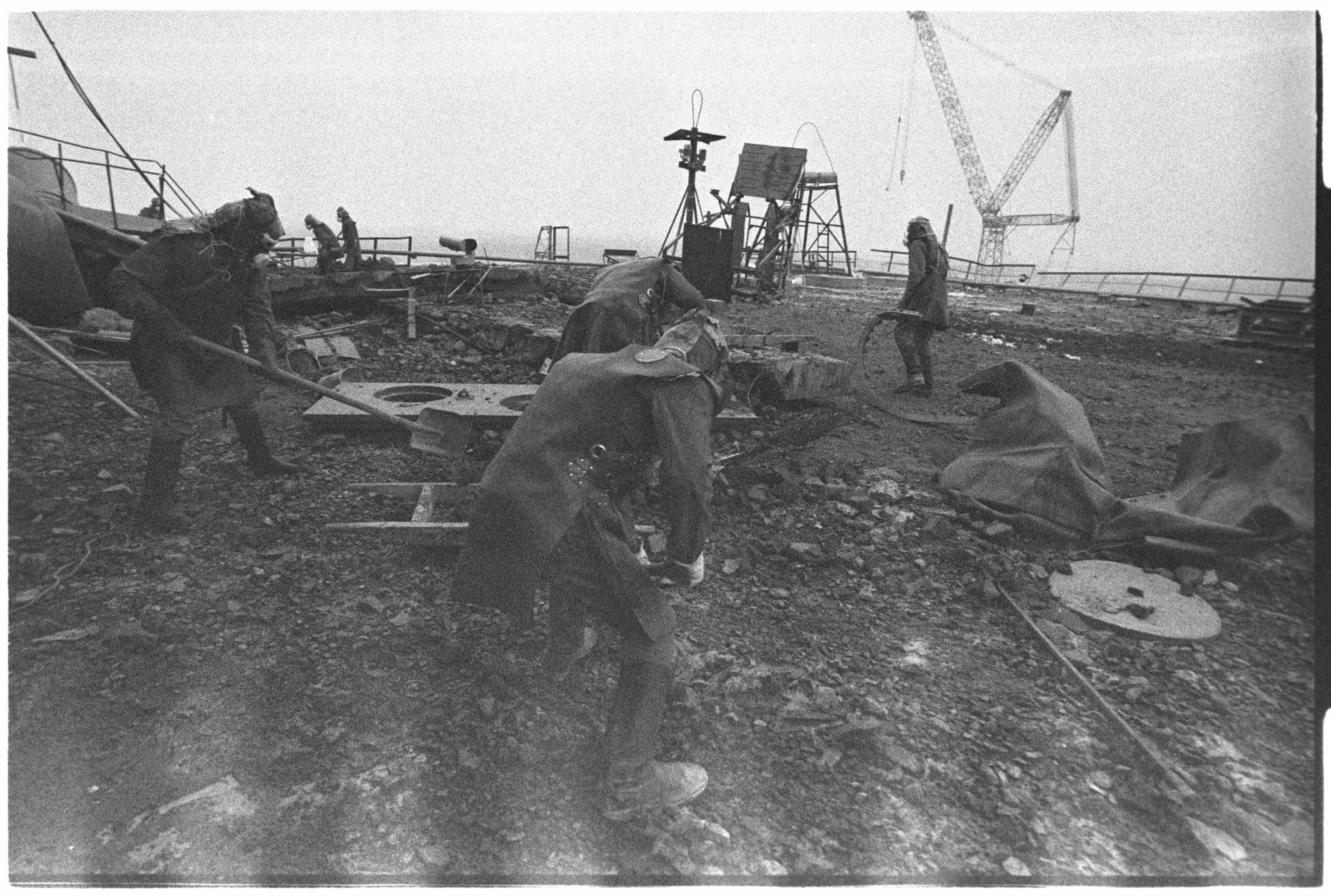 Liquidators removing and shoveling debris from the roof of Reactor No. 3 – of the Chernobyl Nuclear Power Plant, during the cleanup process, September – October 1986. [2048 x 1379]