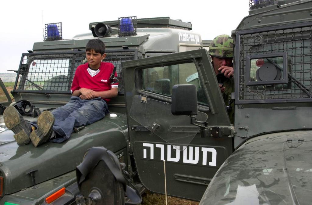 13-year-old Badwan chained to the hood of an Israeli armored car to serve as a human shield, April 22, 2004 (1024 X 672)