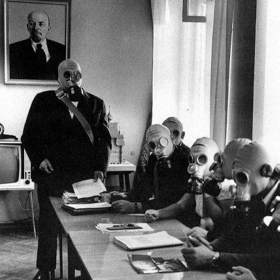 Workers seated a table with an instructor, taking part in a Civil defence drill – with a portrait of Vladimir Lenin on the wall – Soviet Union, c. 1980s. [571 x 571]