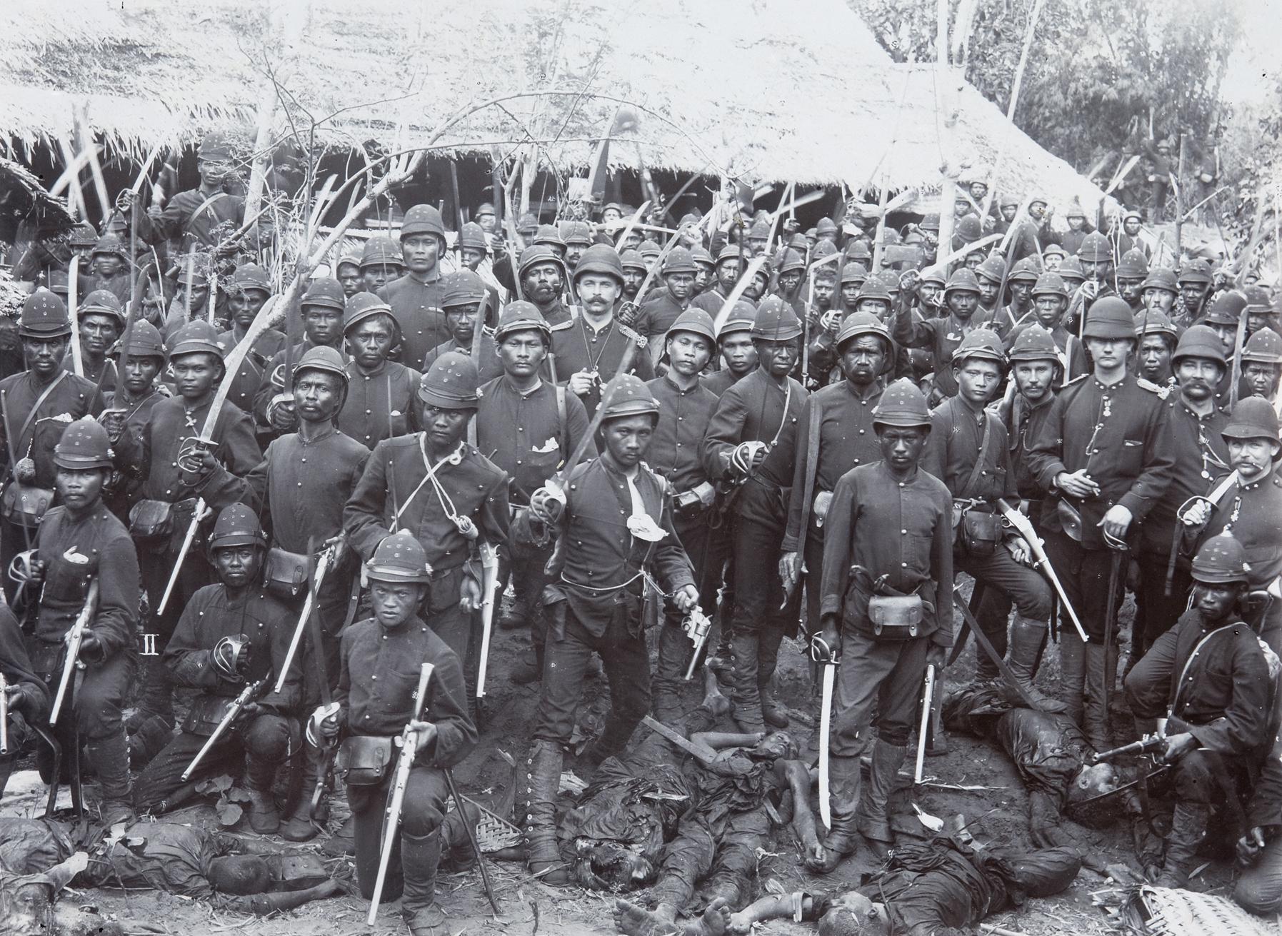 Dutch Royal Netherlands-Indies Army (KNIL) soldiers posing over casualties during the Pedir Expedition, Aceh War, Sumatra, 1898. [1795×1311]