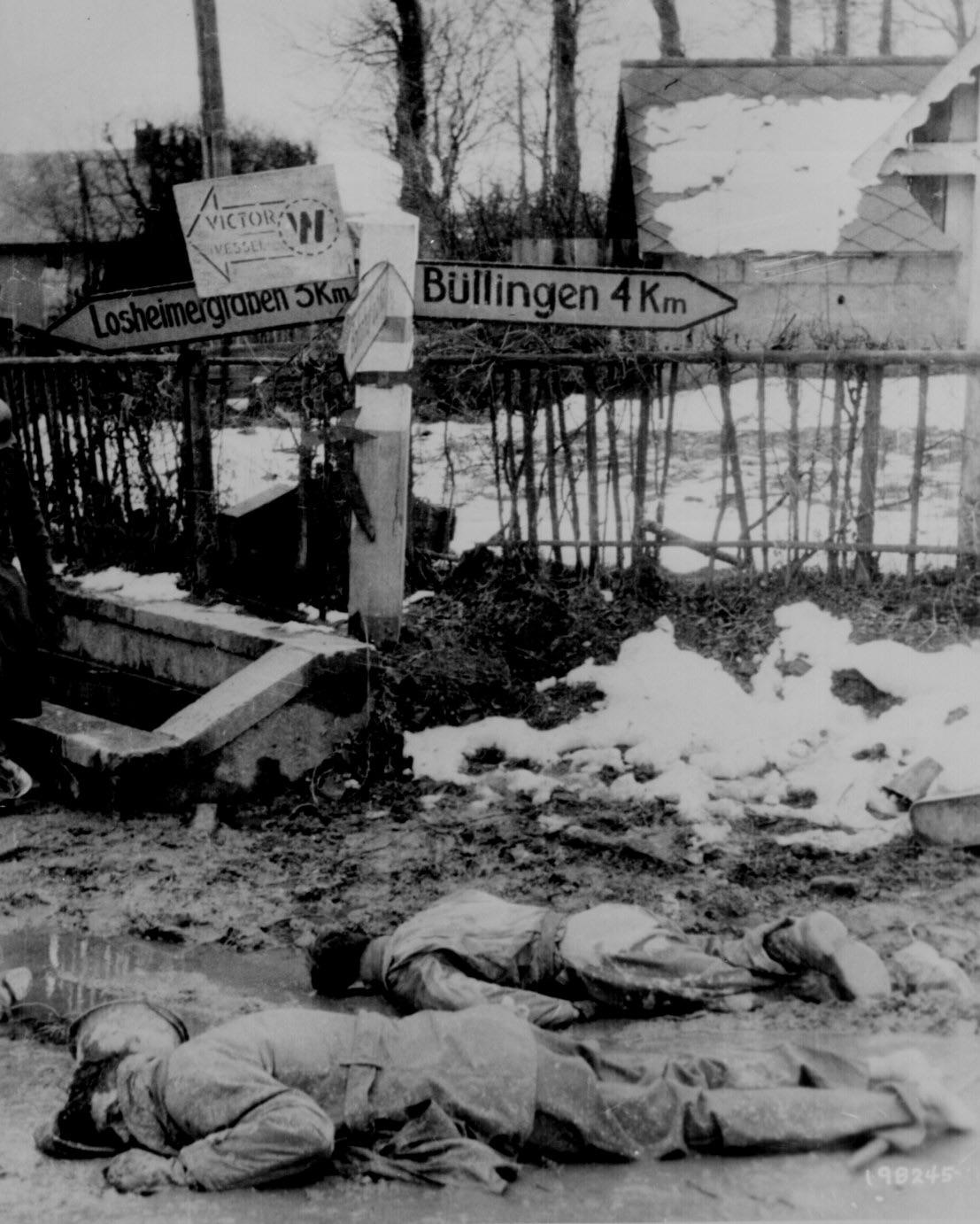 “American soldiers, stripped of all equipment, lie dead, face down in the slush of a crossroads somewhere on the western front.” Captured German photograph. Belgium, ca. December 1944. [1107×1342]