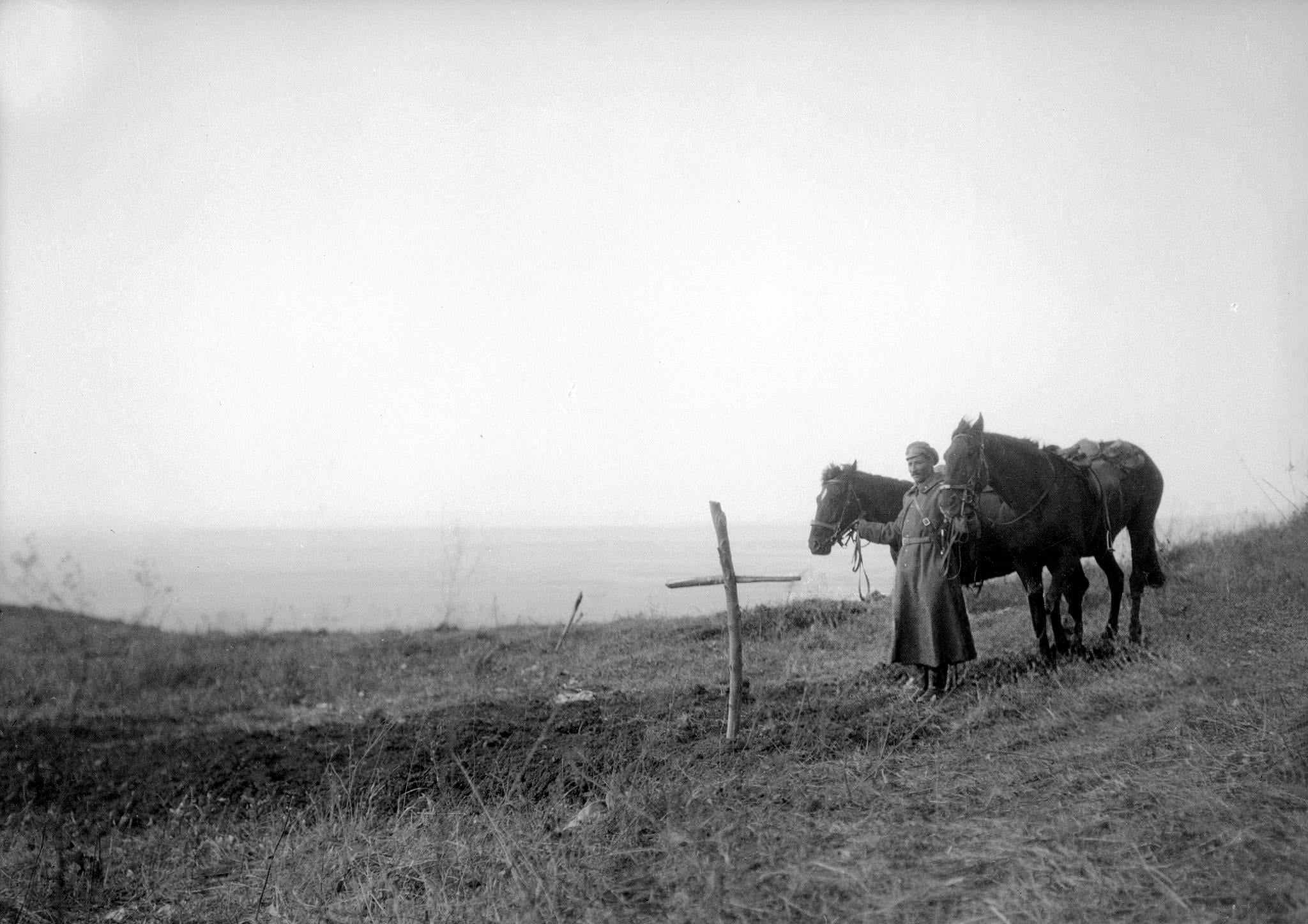 A lone russian soldier stands next to a mass grave in Galicia, September 1914 [2048 x 1448]