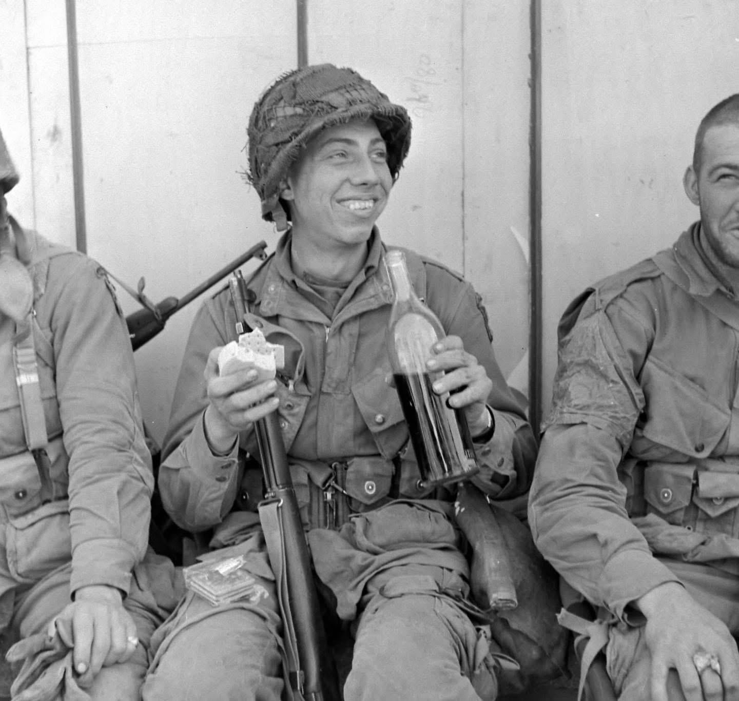 Happy Paratrooper of the 101st Airborne Division enjoys a drink and some chow in Carentan, Normandy – June 1944. Photo by Bob Landry for LIFE Magazine [1440×1336]
