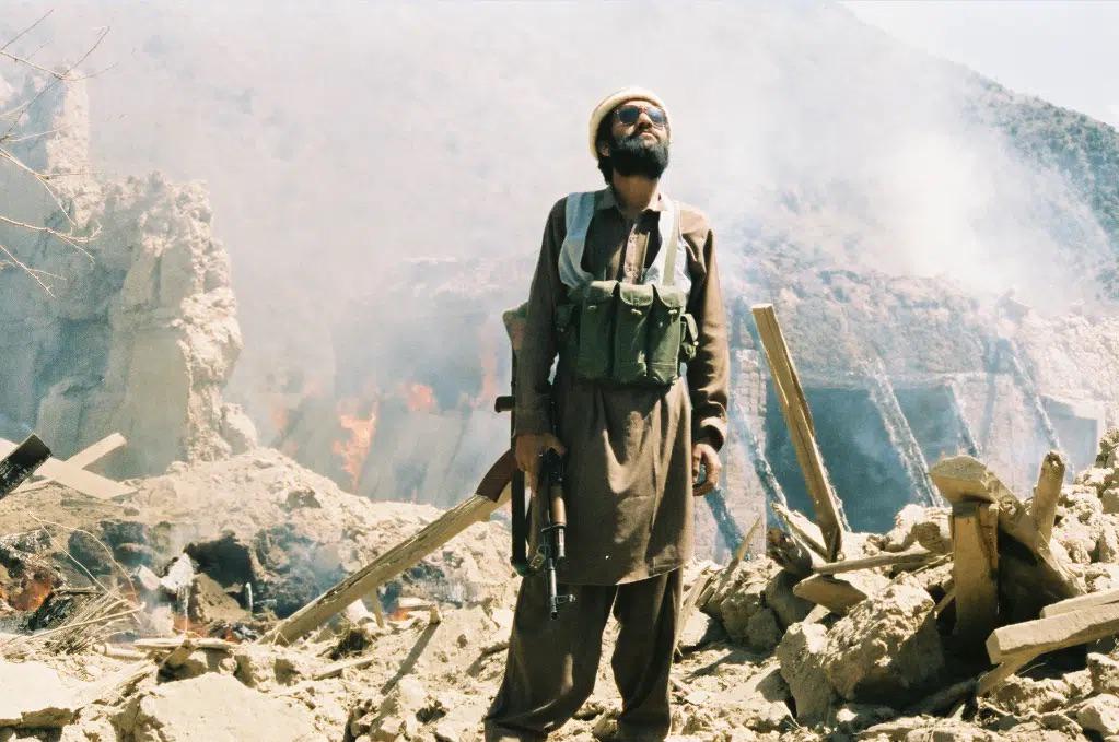 An Afghan man scans the sky after Soviet fighter jets bombed his home in a village near the Pakistani border, his sons were inside the home and were killed in the attack, 1988. (1023×679)