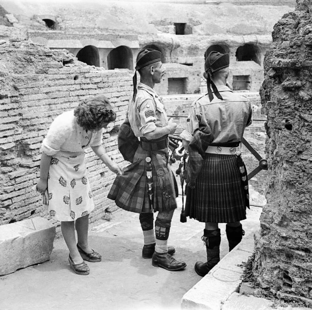 A curious Italian woman inspects the kilt of a Scottish soldier near the Coliseum after the liberation of Rome. Italy – Rome, late June 1944 (WW2) [1007×1000]