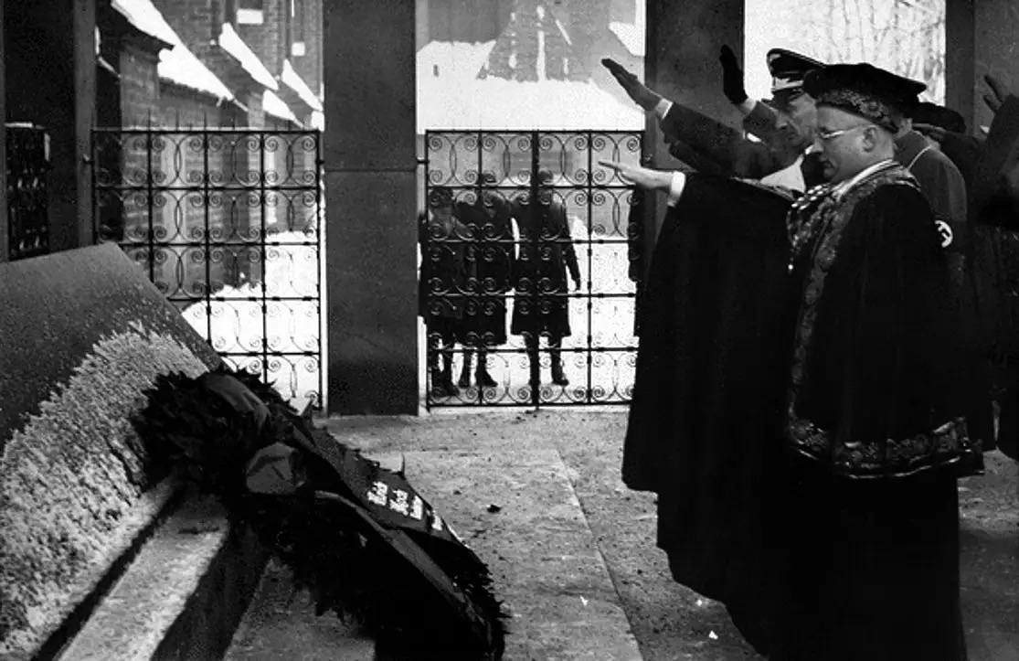 Nazi officials and children behind the fence giving the Hitler salute at the tomb of philosopher Immanuel Kant during a ceremony marking the anniversary of his death, Königsberg Cathedral, East Prussia, February 1937. [1115×723]