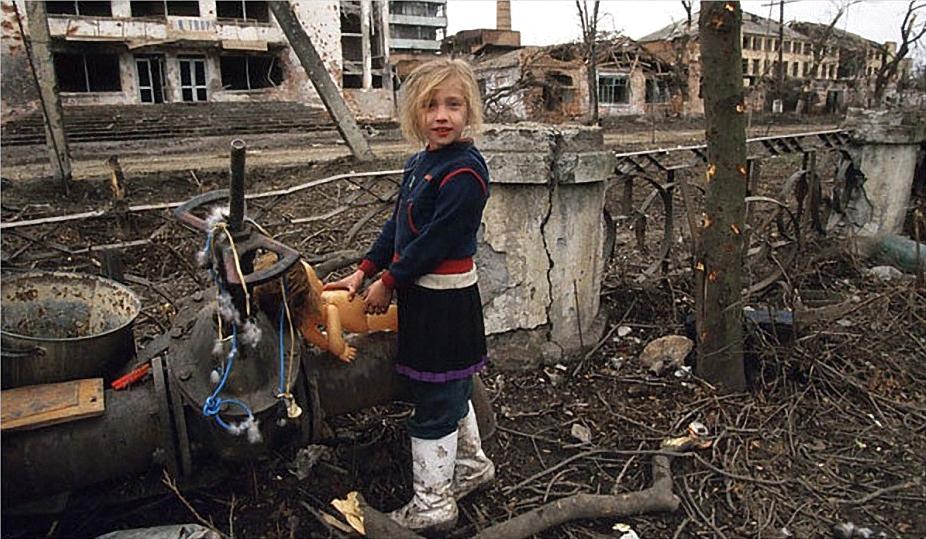 Girl with a doll in the ruins of Grozny, 2002.[926×539]