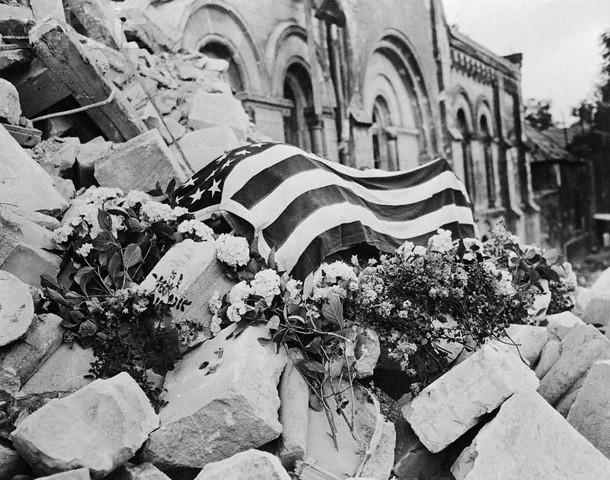 The flag draped body of Major Thomas D. Howie laid to rest on the rubble of Sainte-Croix Church after he was killed during the Battle of Saint-Lô. Normandy, France, July 1944 [610 × 480]