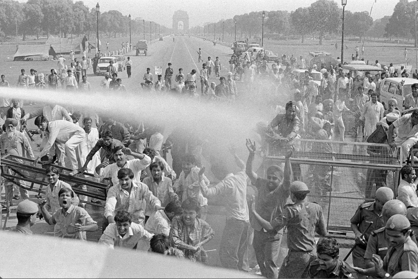 Police using water cannons to disperse a crowd gathered to commemorate victims of the 1984 communal violence at India Gate in New Delhi, 8 years after the assassination of Indira Gandhi by two of her Sikh bodyguards triggered the unrest that resulted in about 3,000 deaths in India. (1992) [1388×925]
