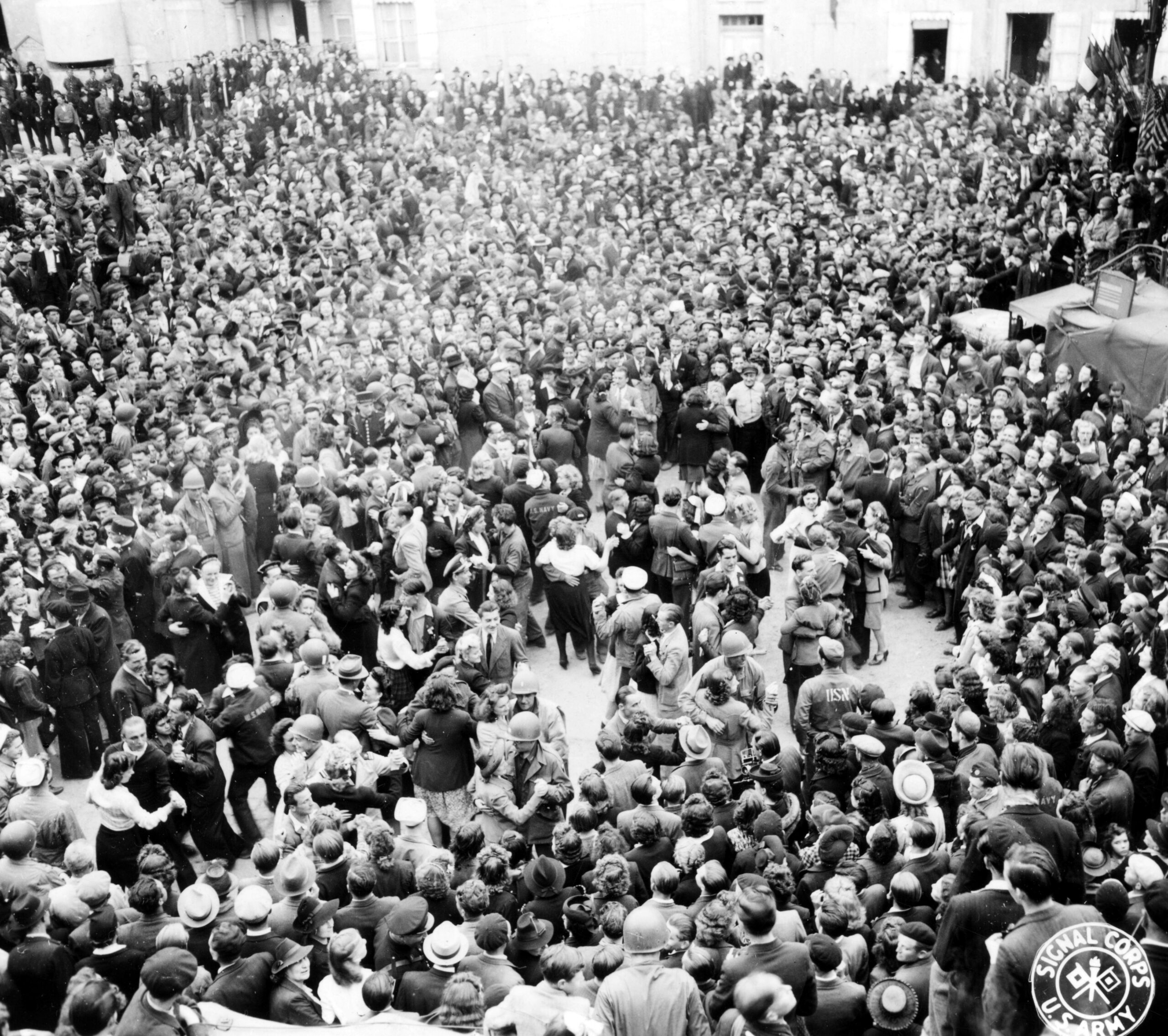 U.S. soldiers and sailors dancing with French citizens in the Place De La Republique, Cherbourg, on the evening of Bastille Day. 14 July 1944 [4802 × 4259]