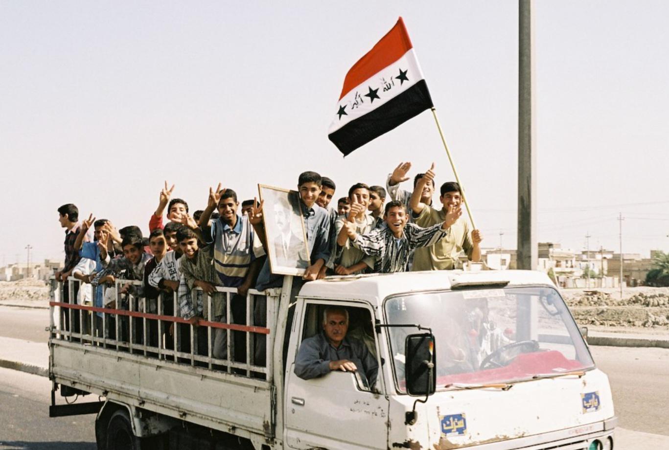 Children in Basra, Iraq with a portrait of Saddam Hussein. (2002) [1367×920]
