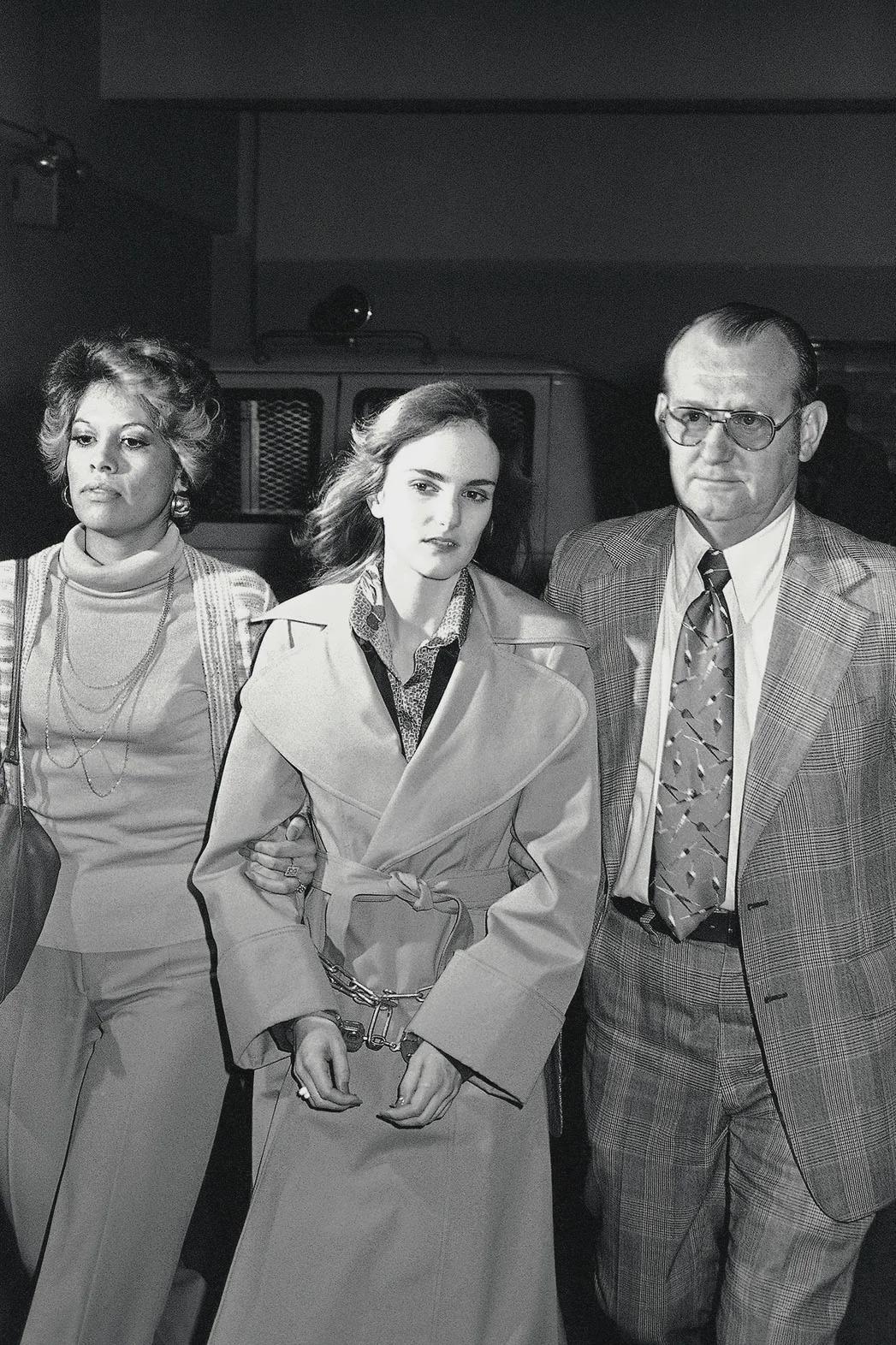 Newspaper heiress Patricia Hearst, 22, is escorted by U.S. Marshals from the Federal Building in San Francisco back to the San Mateo County Jail following a day in court during her trial for assisting the Symbionese Liberation Army during a bank robbery (California, March 5, 1976) [1054 x 1072].