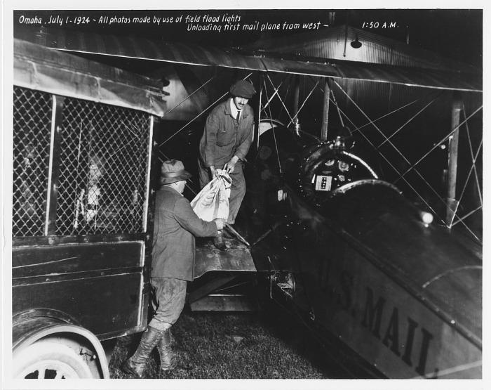 Ground crew unloading U.S. Air Mail from the first westbound transcontinental mail plane in Omaha, Nebraska, 1 July 1924. [700×555]