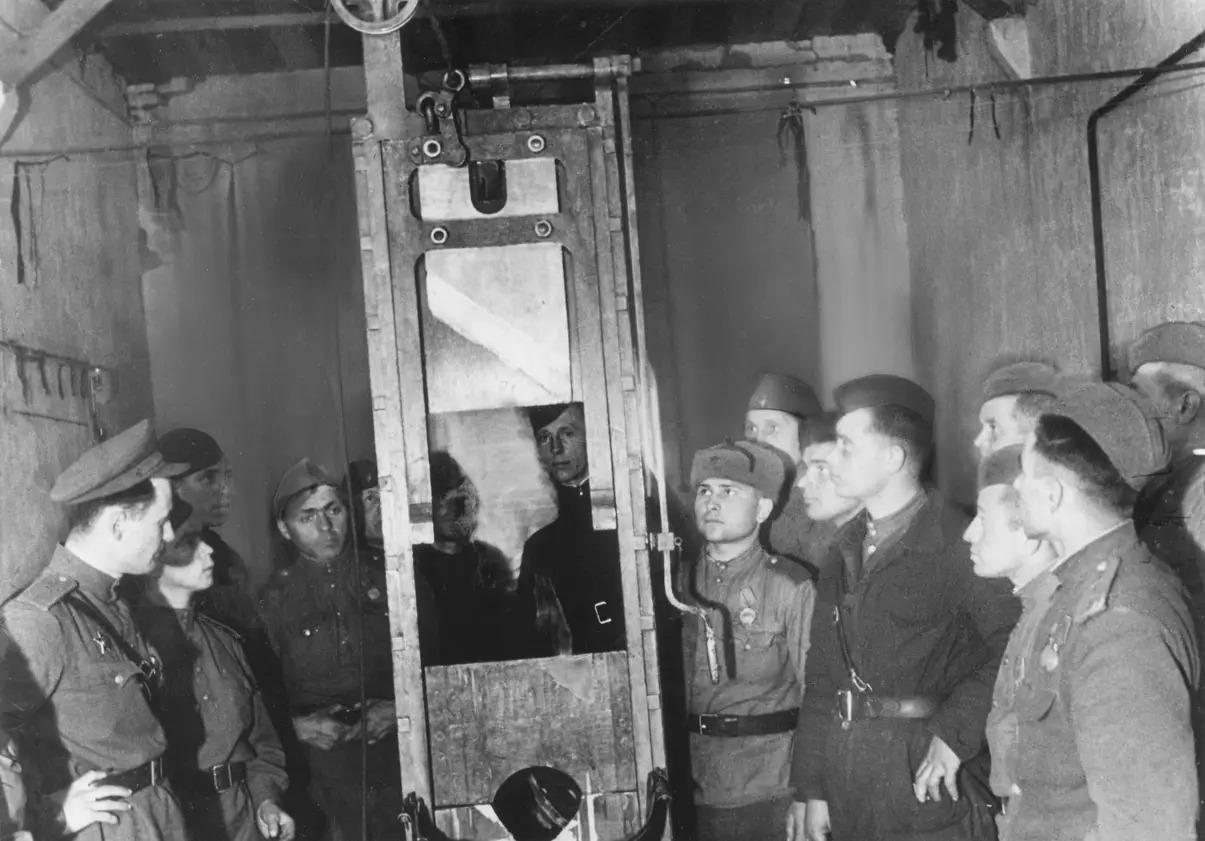 Soviet soldiers examine the guillotine in Berlin-Plötzensee Prison, May 1945, photo by Ivan Shagin. [1205x841px]