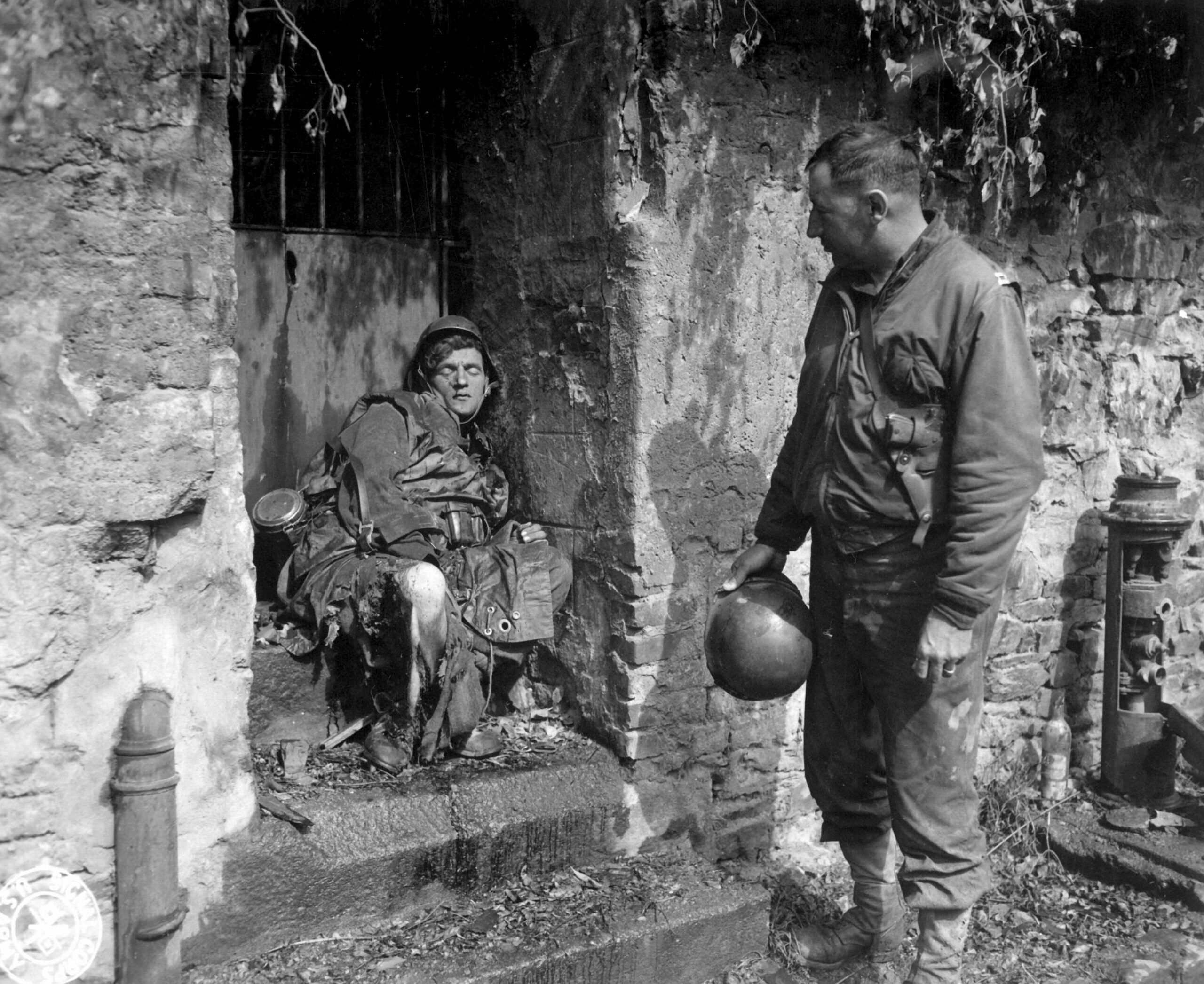 U.S. Army Captain Earl Topley stares at a dead German soldier after the Battle of Cherbourg. France, 27 June 1944 [2805 × 2293]