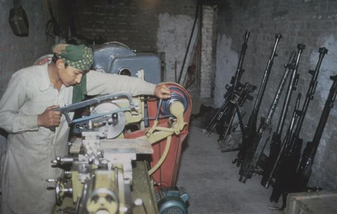 A young Afghan freedom fighter working at a gunsmith station inside an underground Mujahideen hideout in Khost province, 1985. (1179×747)