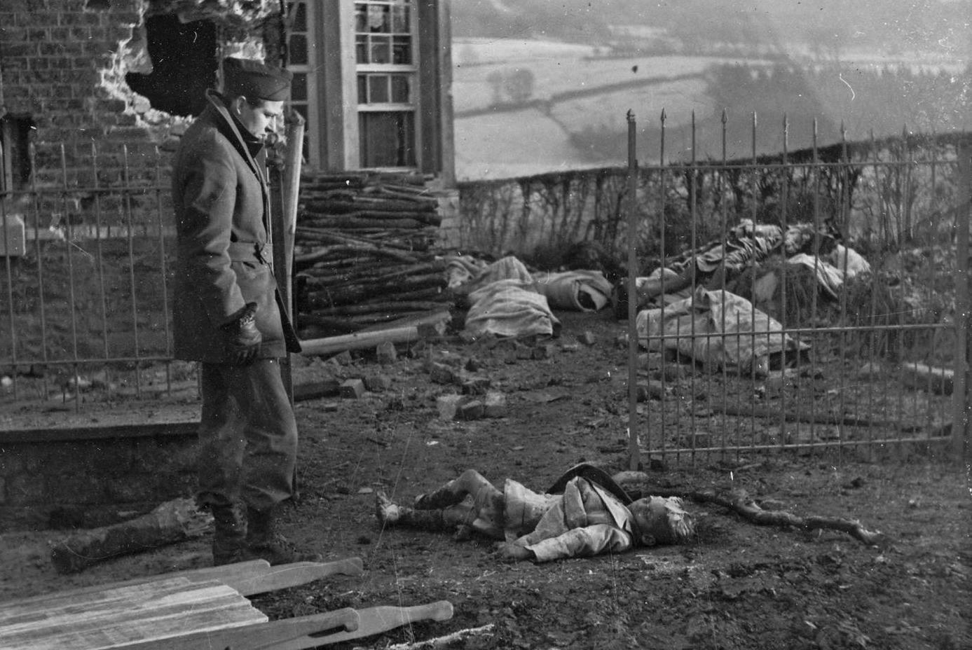 French War correspondent Jean Marin looks at a boy killed by SS troops of the Kampfgruppe Peiper at the Legaye house in Stavelot, Belgium. December, 1944. [1387 × 928].