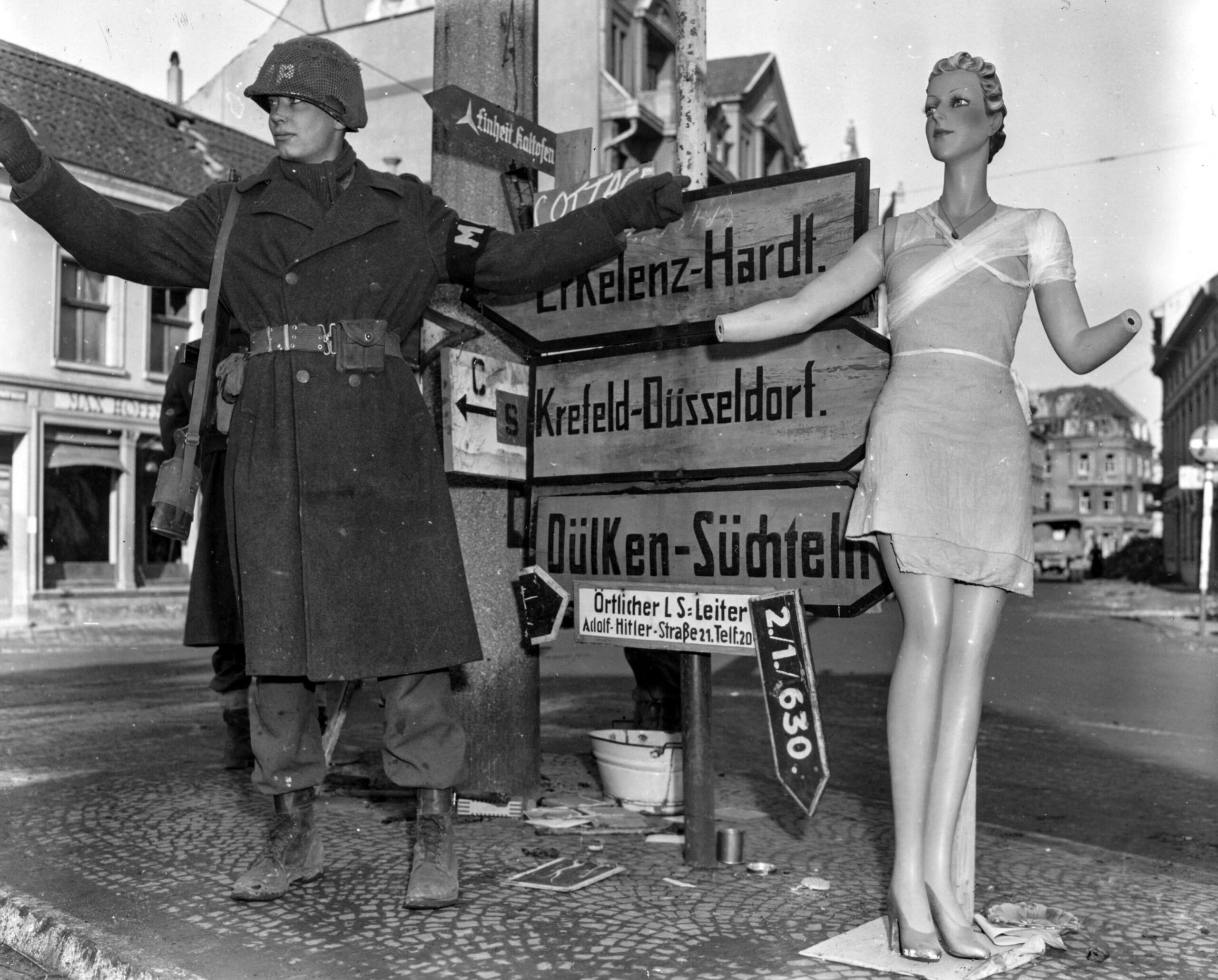 A mannequin helping a military policeman to direct traffic in the recently captured German town Viersen. (1945) [3072×2473]