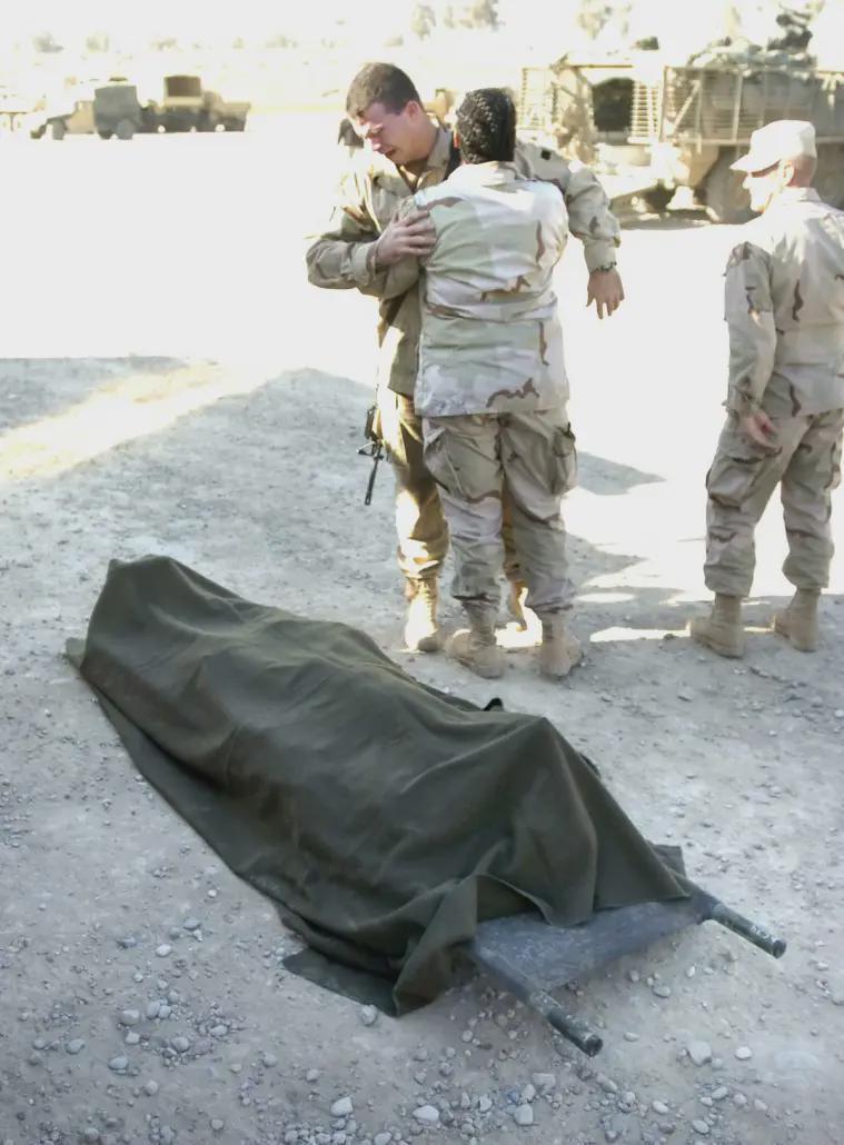 CPL Nathan Almquist is comforted by a member of his unit as he stands over the body of a Task Force Olympia soldier after a suicide bombing at Forward Operating Base Marez in Mosul, Iraq on Tuesday, Dec. 21, 2004. [759 × 1030]